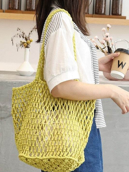 Miss Sparkling yellow braided net beach tote carried by a woman in casual outfit holding a coffee cup