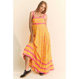 yellow floral sundress for travel with pink accents worn by woman in black sneakers
