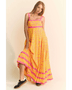yellow floral sundress for travel with pink accents worn by woman in black sneakers