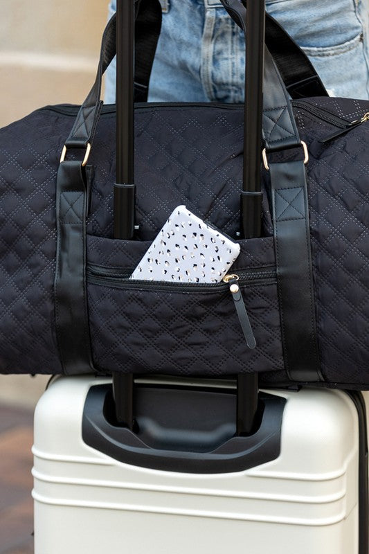 Black Babe Beachwear Zahra carry on overnight bag with quilted design on white suitcase handle