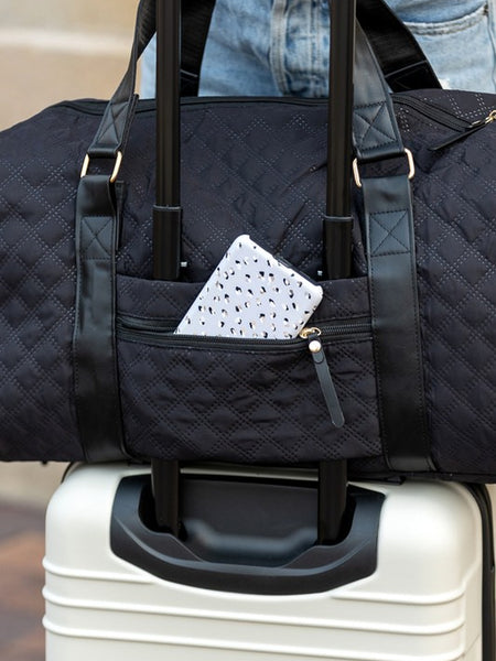 Black Babe Beachwear Zahra carry on overnight bag with quilted design on white suitcase handle