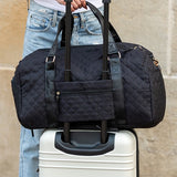 Black Babe Beachwear Zahra carry on overnight bag attached to white suitcase handle