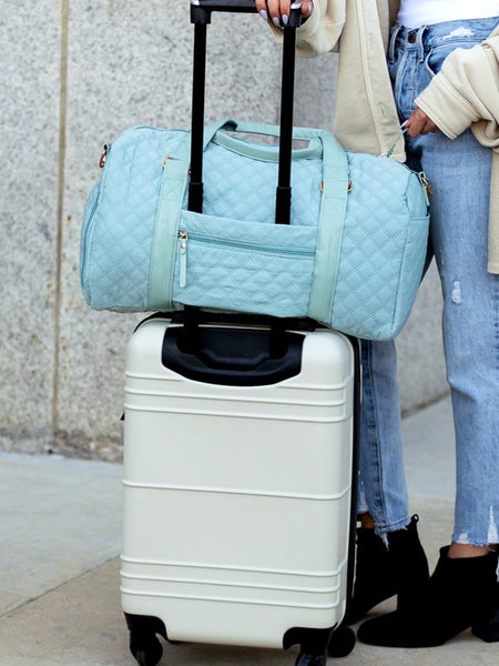 Babe Beachwear Zahra carry on overnight bag in light blue quilted design on white suitcase