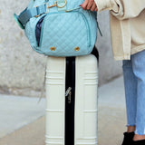 Babe Beachwaer Zahra carry on overnight bag in light blue placed on white suitcase with black zipper