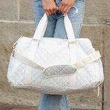 Babe Beachwaer Zahra carry on overnight bag in white quilted design held by person in casual jeans