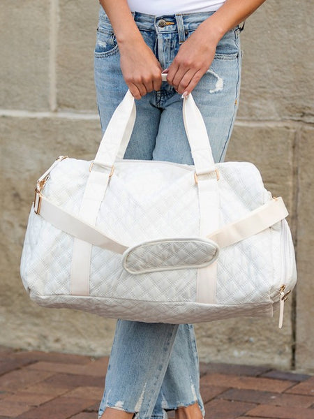 Babe Beachwaer Zahra carry on overnight bag in white quilted design held by person in casual jeans